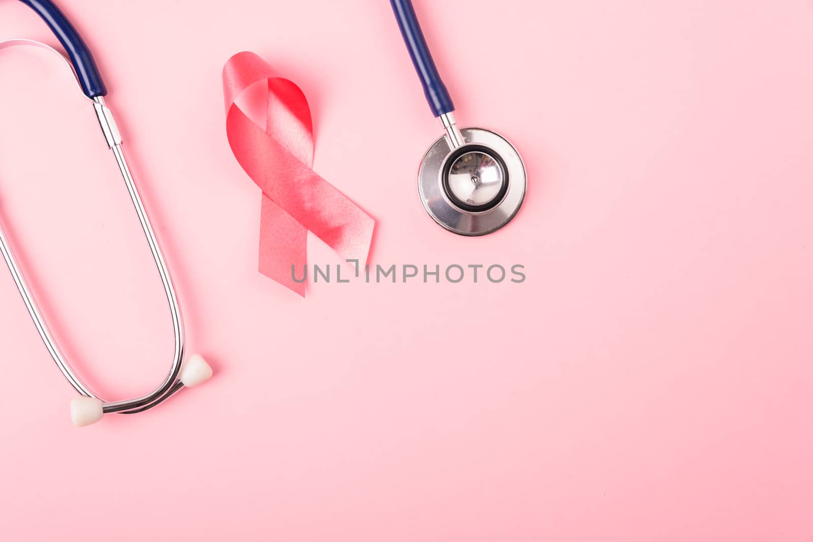 Breast Cancer Awareness Month Health concept, top view flat lay pink ribbon and stethoscope on pink background with copy space for your text