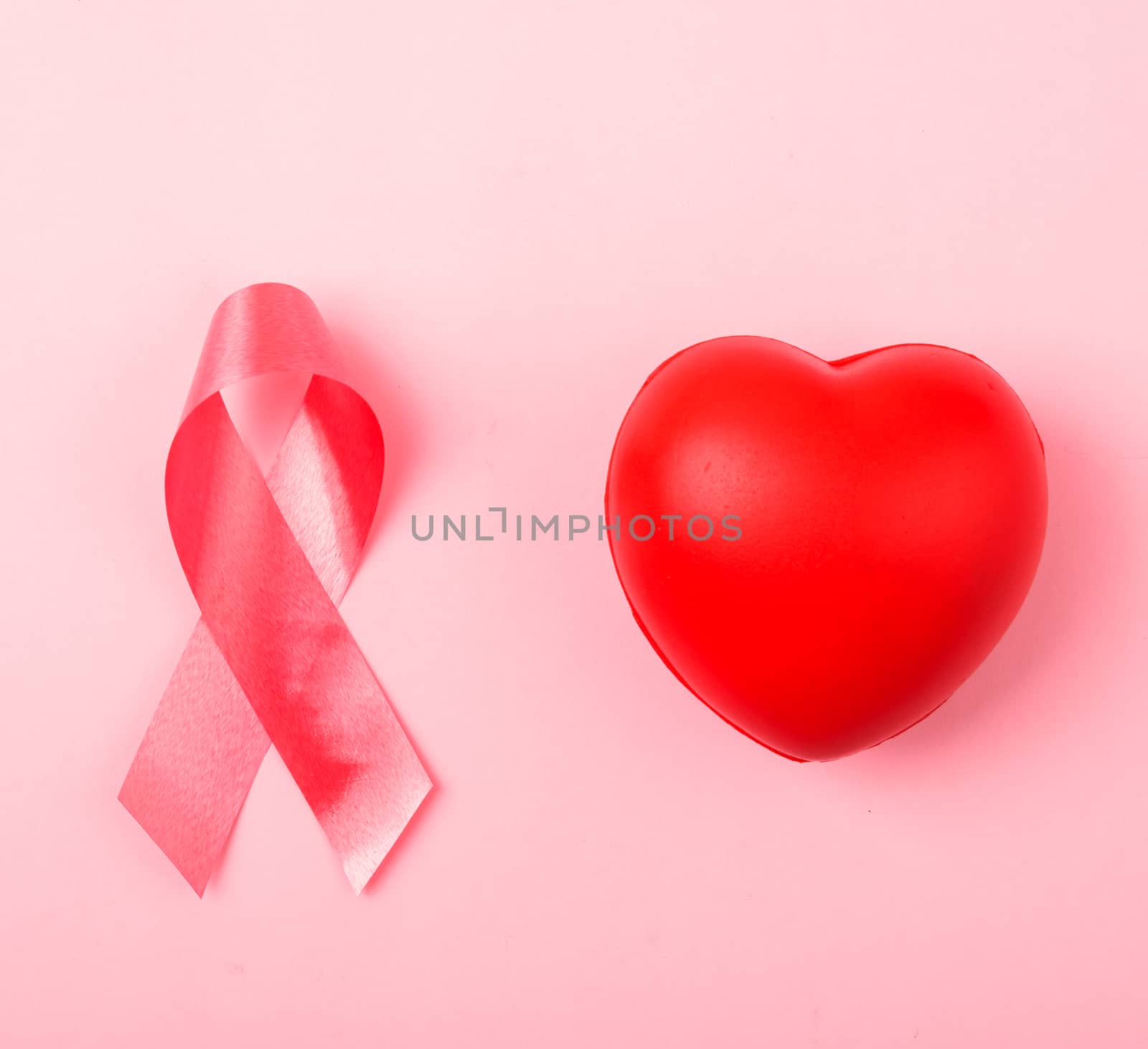Breast cancer month health concept, flat lay top view, put pink ribbon and Red Heart on pink background with copy space for your text