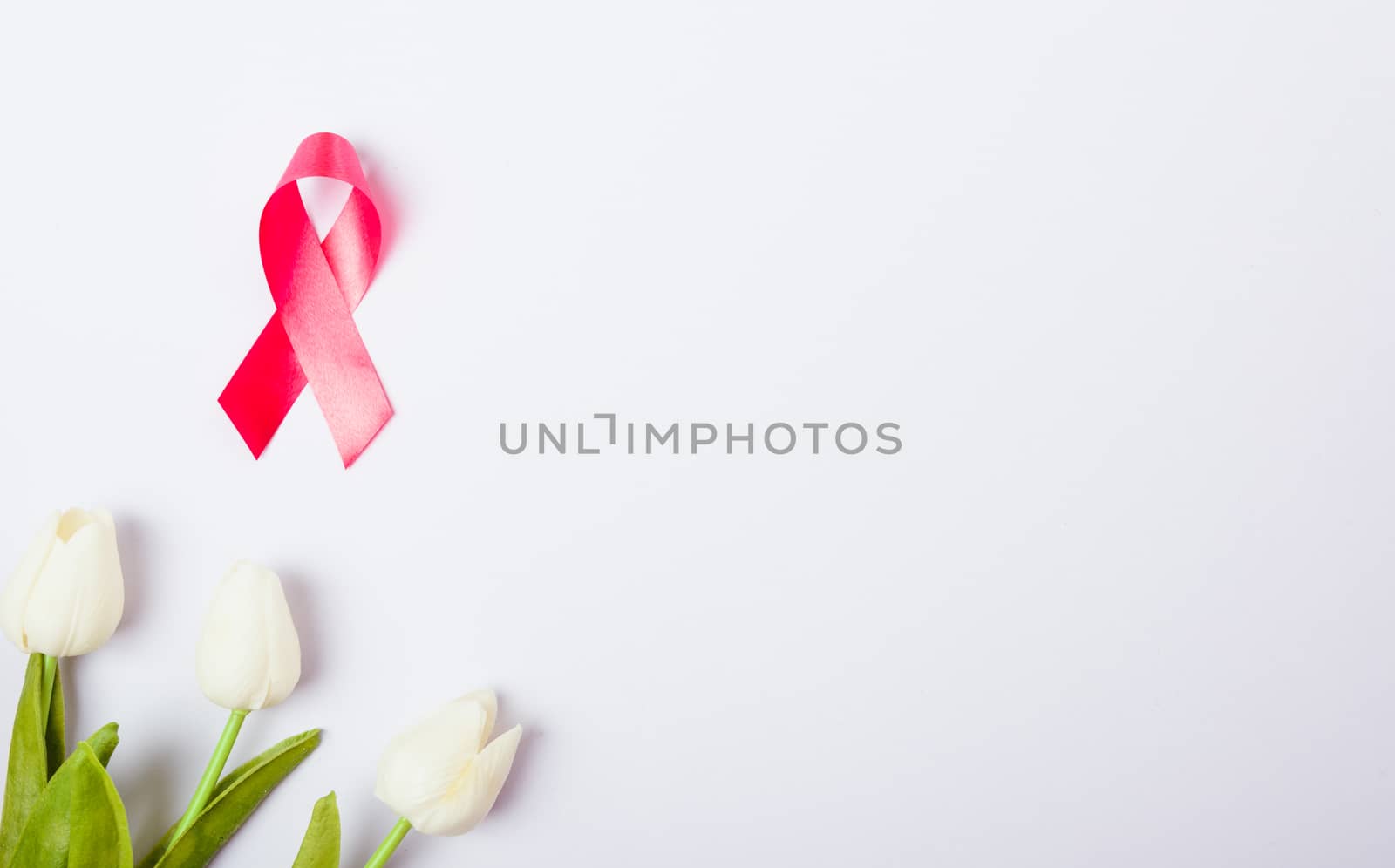 Breast cancer month concept, flat lay top view, pink ribbon and Tulip Flower on white background with copy space for your text