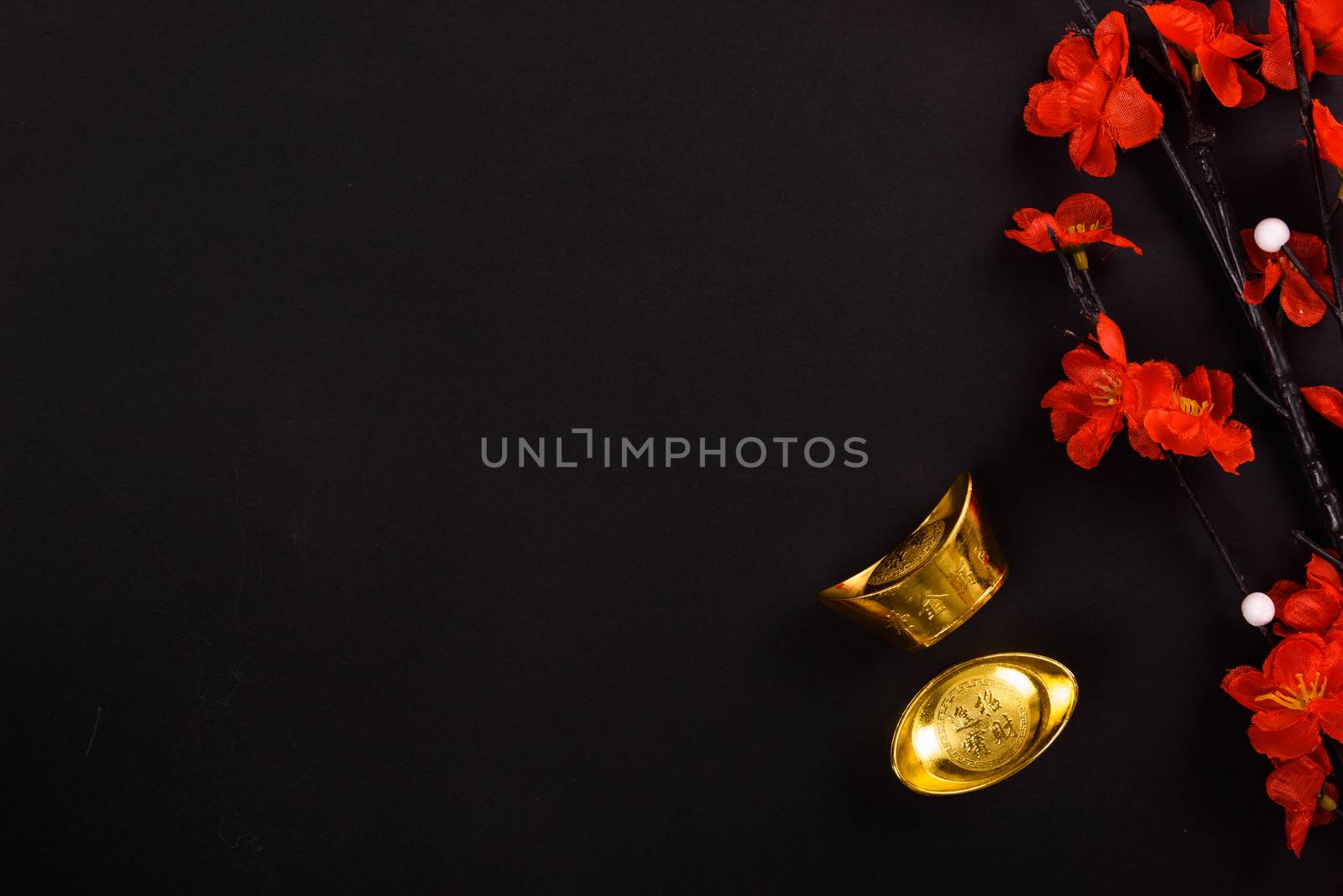 Chinese New Year, flat lay top view, gold bar and Chinese Flower on black background with copy space for your text