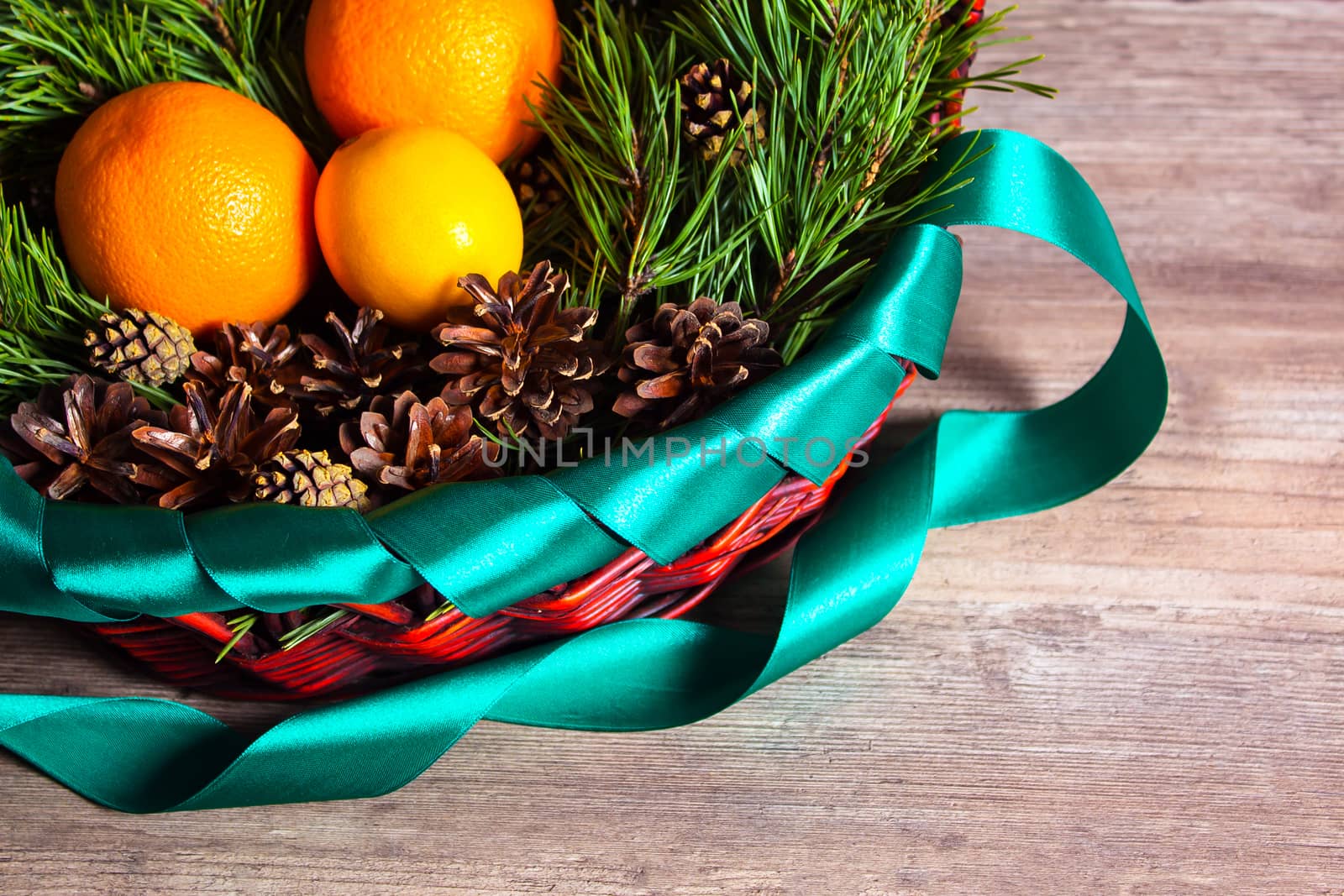 Christmas or new year  fruit basket top view. Oranges and lemon lie in a basket with a Christmas tree and Christmas cones. New year flat lay