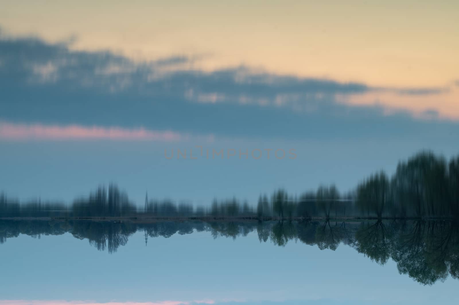 Abstract flipped evening landscape. A lot of sky in reflection from the water mirror.