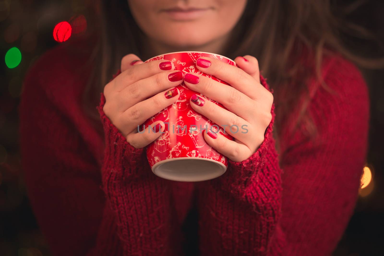 Woman holding winter cup with nice Christmas motive close up on Christmas background.