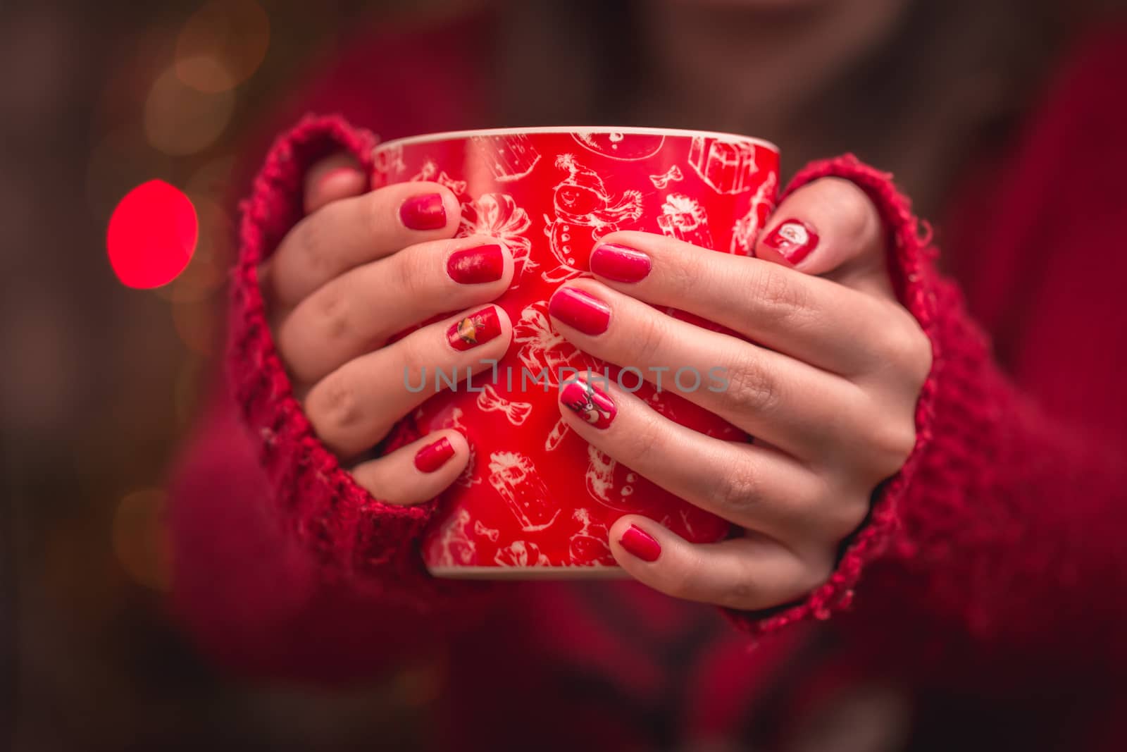 Woman's hand holding a red cup of coffee. With a beautiful winter manicure. Drink, fashion, morning