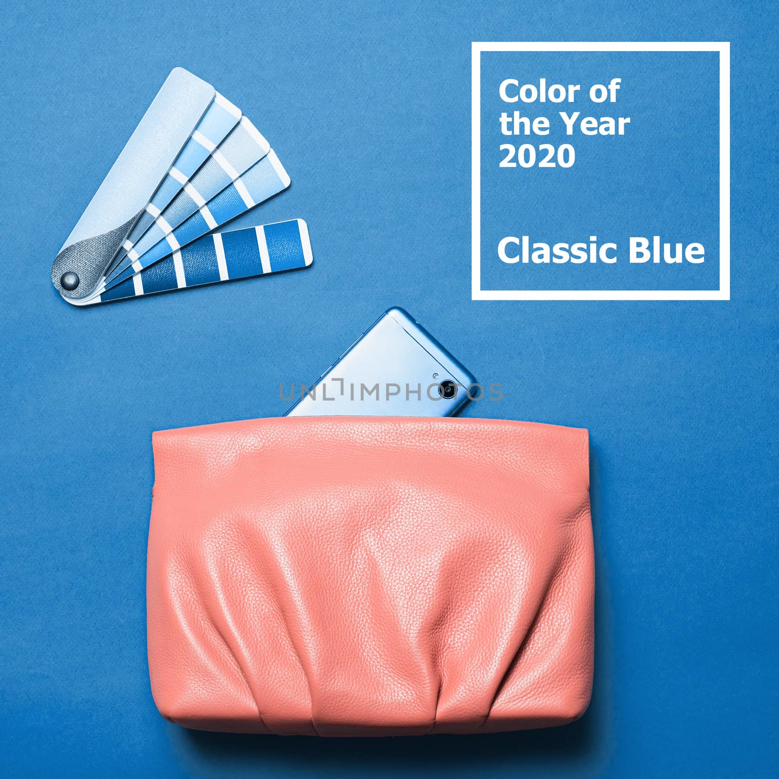 Pink coral female leather bag over classic blue 2020 color background. Color of year 2020 concept for fashion and clothing industry.