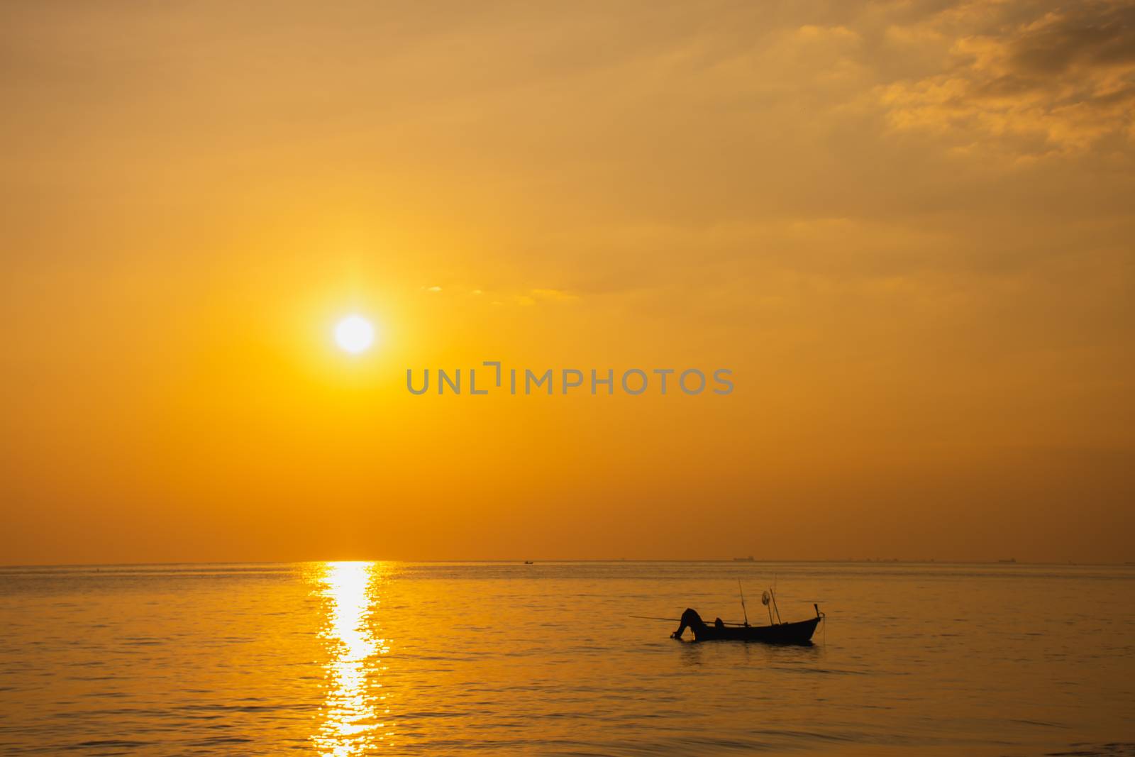 Black silhouette, beautiful sunset with a fishing boat, Mae Ramphueng Beach, Rayong Province, Thailand
