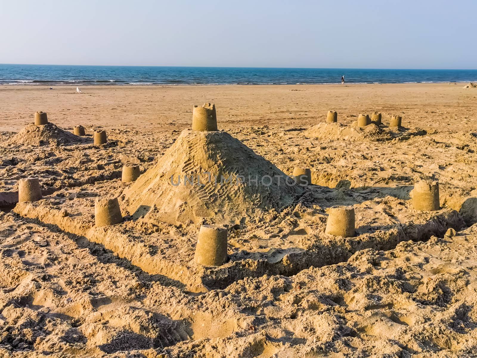 Sand castle structures made of sand on the beach, kids and adult creativity, summer season background