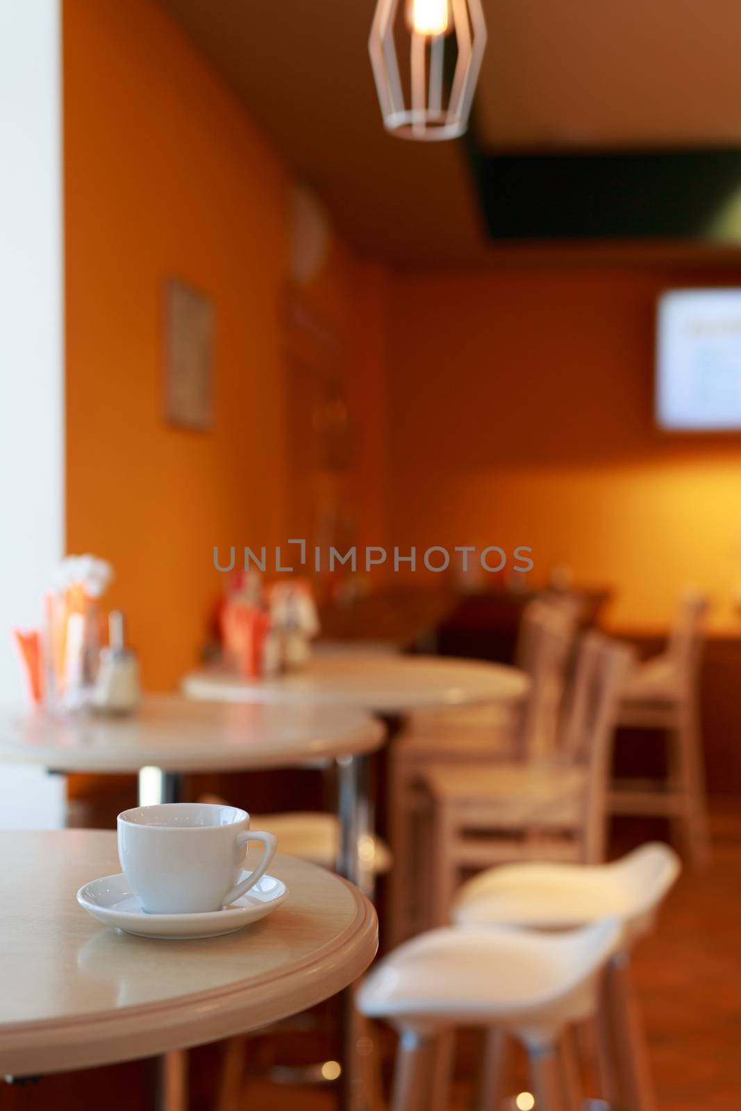 coffee Cup is on the table in a cafe with a blurry background , white tea Cup, Breakfast, cafe background orange