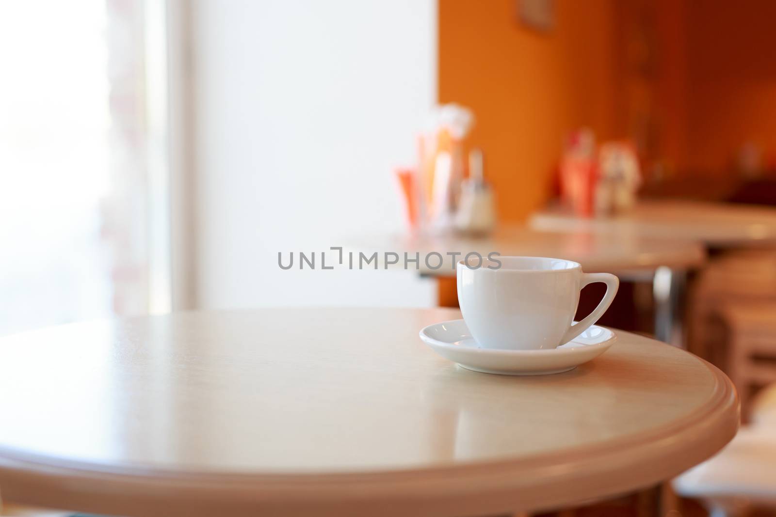 coffee Cup is on the table in a cafe with a blurry background , white tea Cup, Breakfast, cafe background orange by dikkens