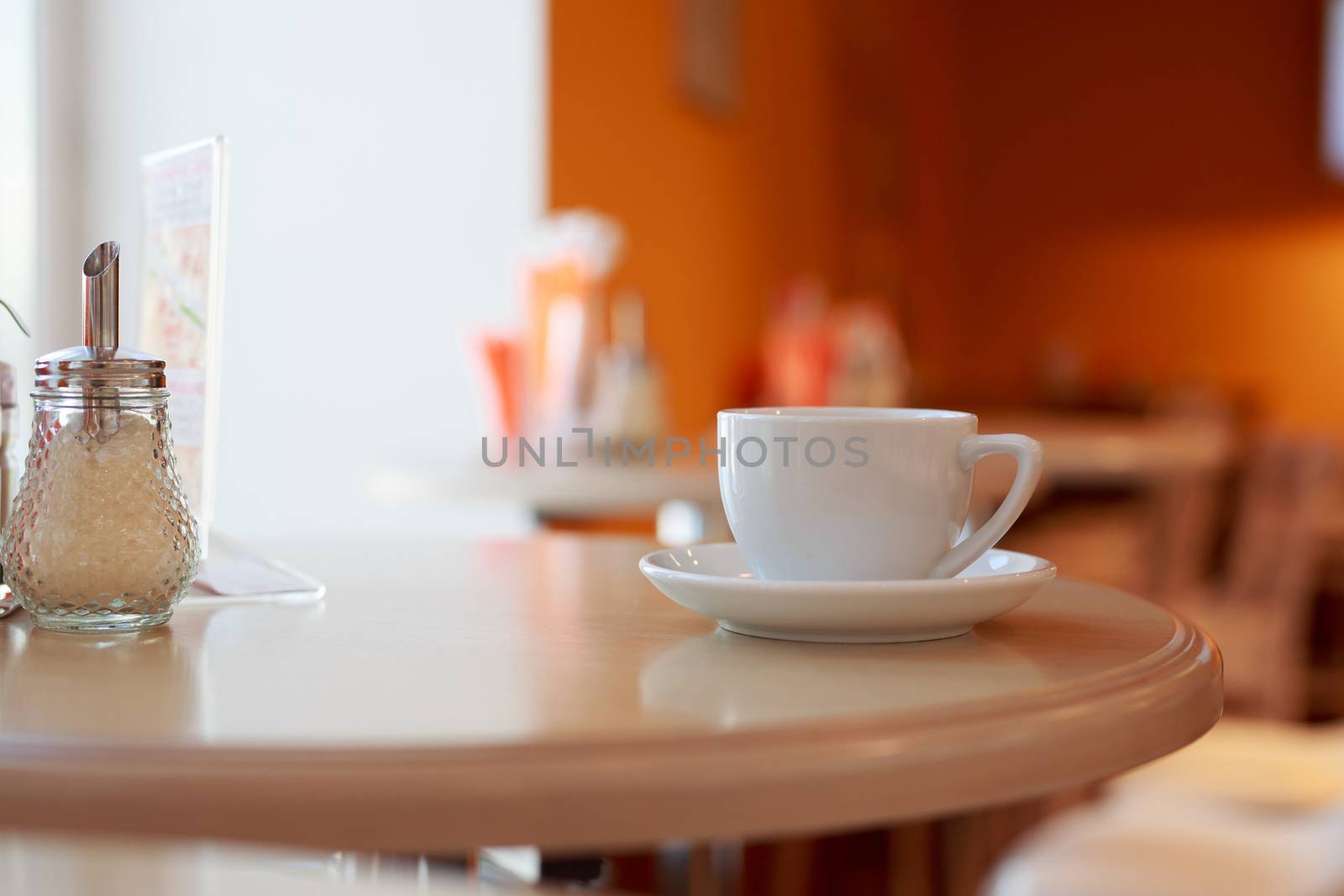 coffee Cup is on the table in a cafe with a blurry background , white tea Cup, Breakfast, cafe background orange