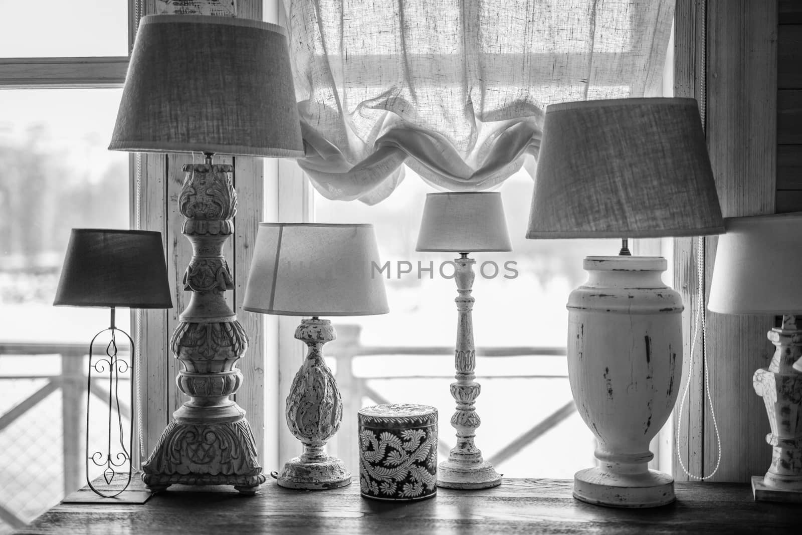 old table lamp standing on the table, carved legs, lots of lamps, a vintage lamp bw