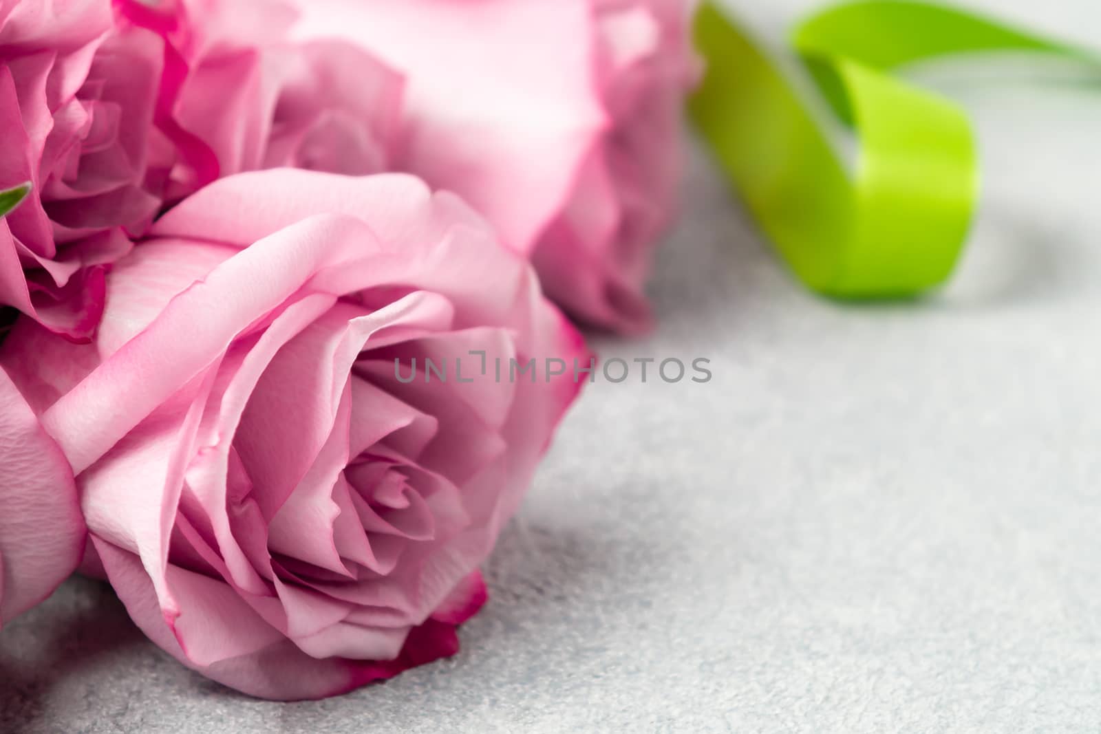Flower arrangement - a bouquet of pink roses on a concrete surface, template for design or greeting card, place for text, copy space.