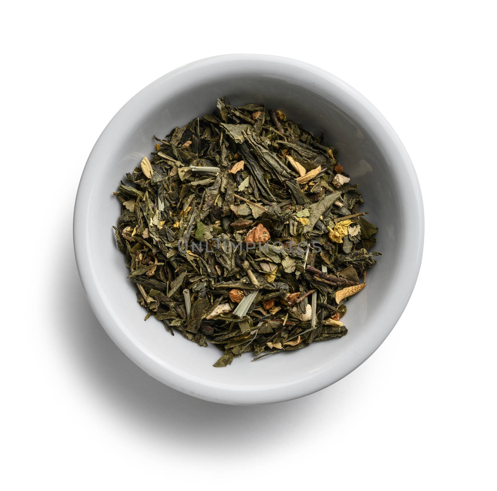Green tea with aromatic additives. Top view on white background.