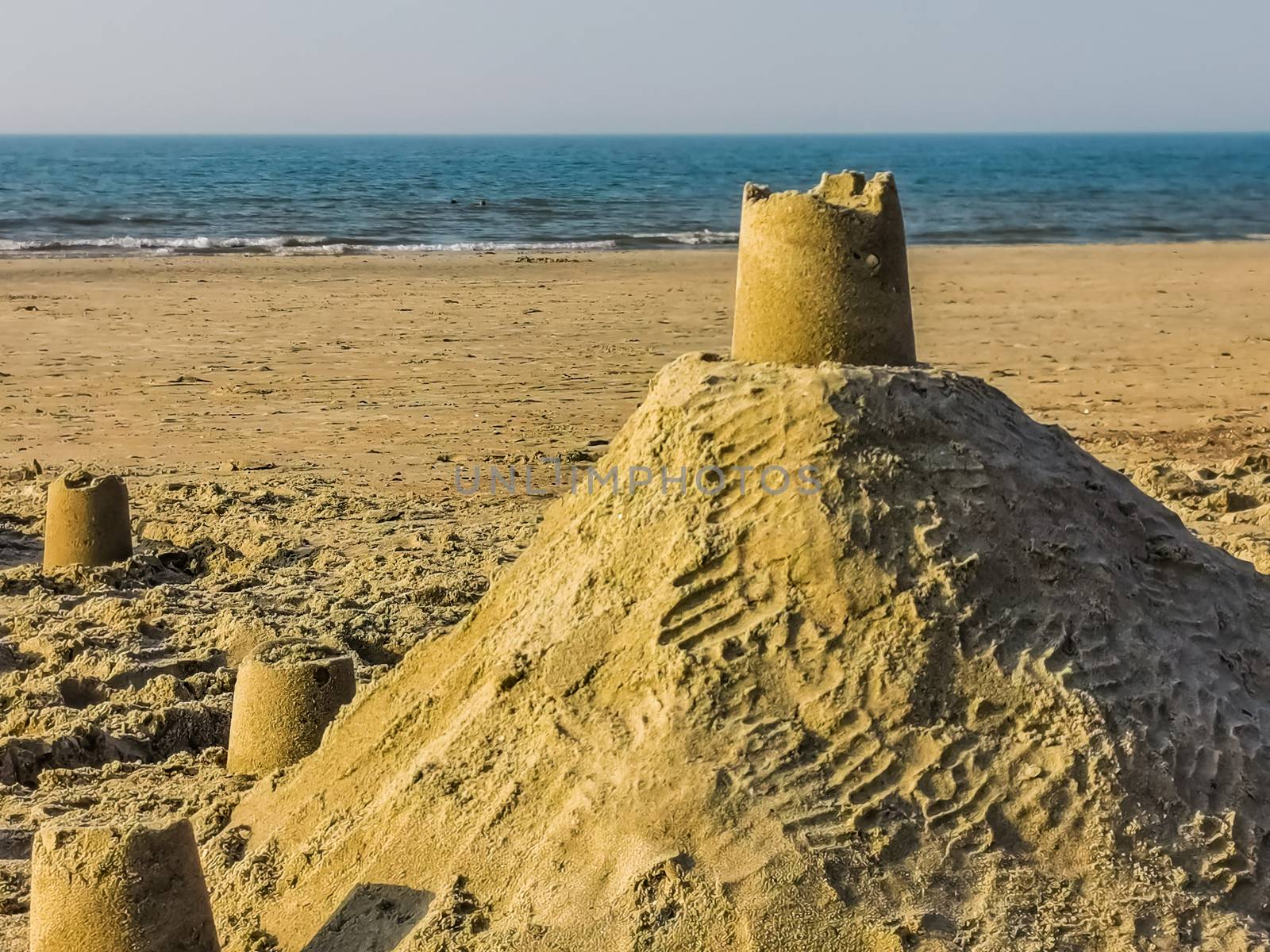 close up of a sand castle building on the beach, summer season and holiday background