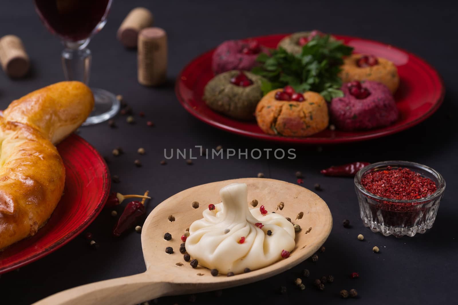 Georgian food on black table. khinkali, phali,  khachapuri with tomatos, adjika and a glass of wine.