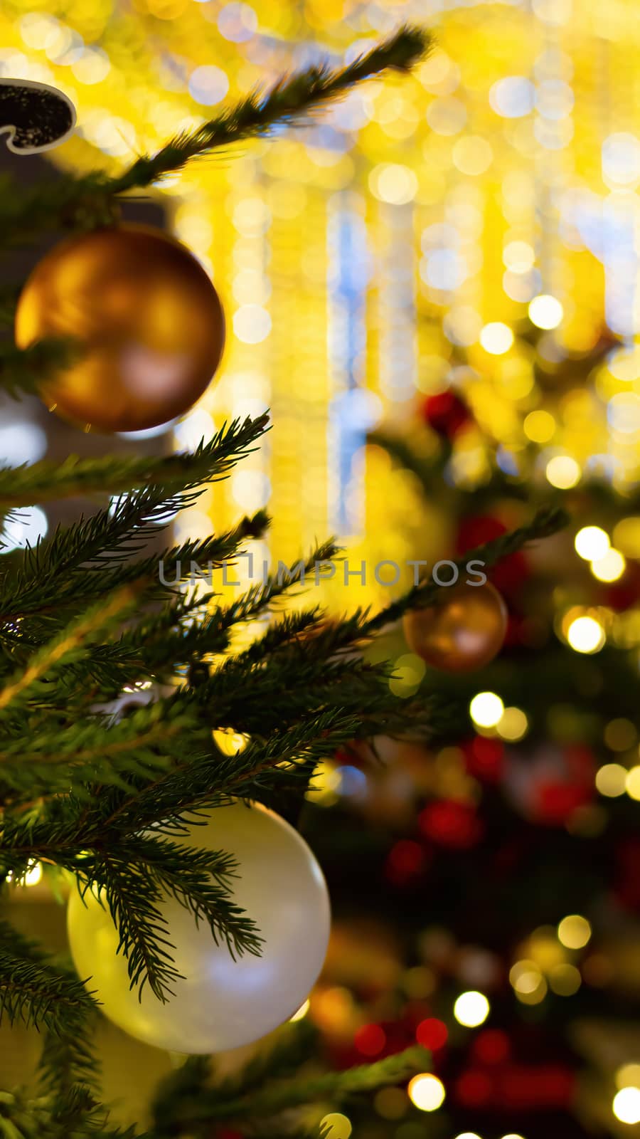 Colorful bokeh defocused Christmas garlands, Christmas market. Festive abstract background. The vertical format.