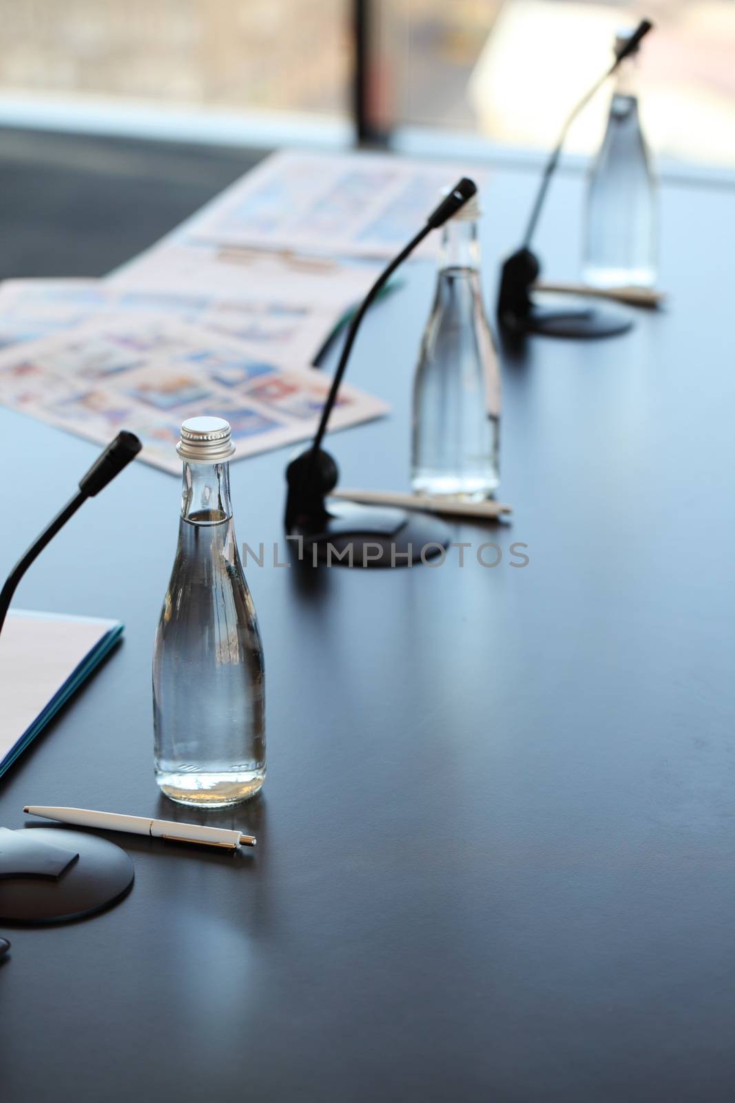Conference room table for business meeting with microphones and bottles of water