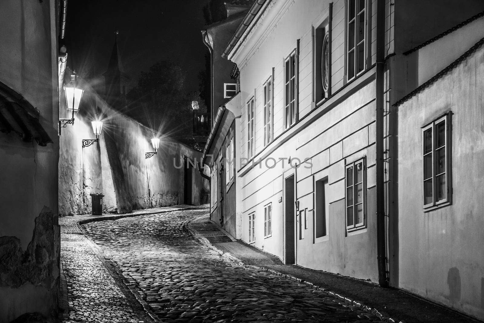 Narrow cobbled street in old medieval town with illuminated houses by vintage street lamps, Novy svet, Prague, Czech Republic. Night shot by pyty