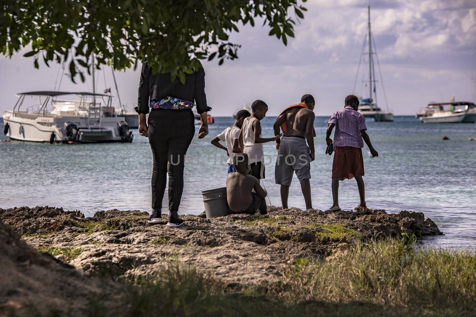 BAYAHIBE, DOMINICAN REPUBLIC 23 DECEMBER 2019: Poor Dominican children play in Bayahibe beach in total happiness and joy