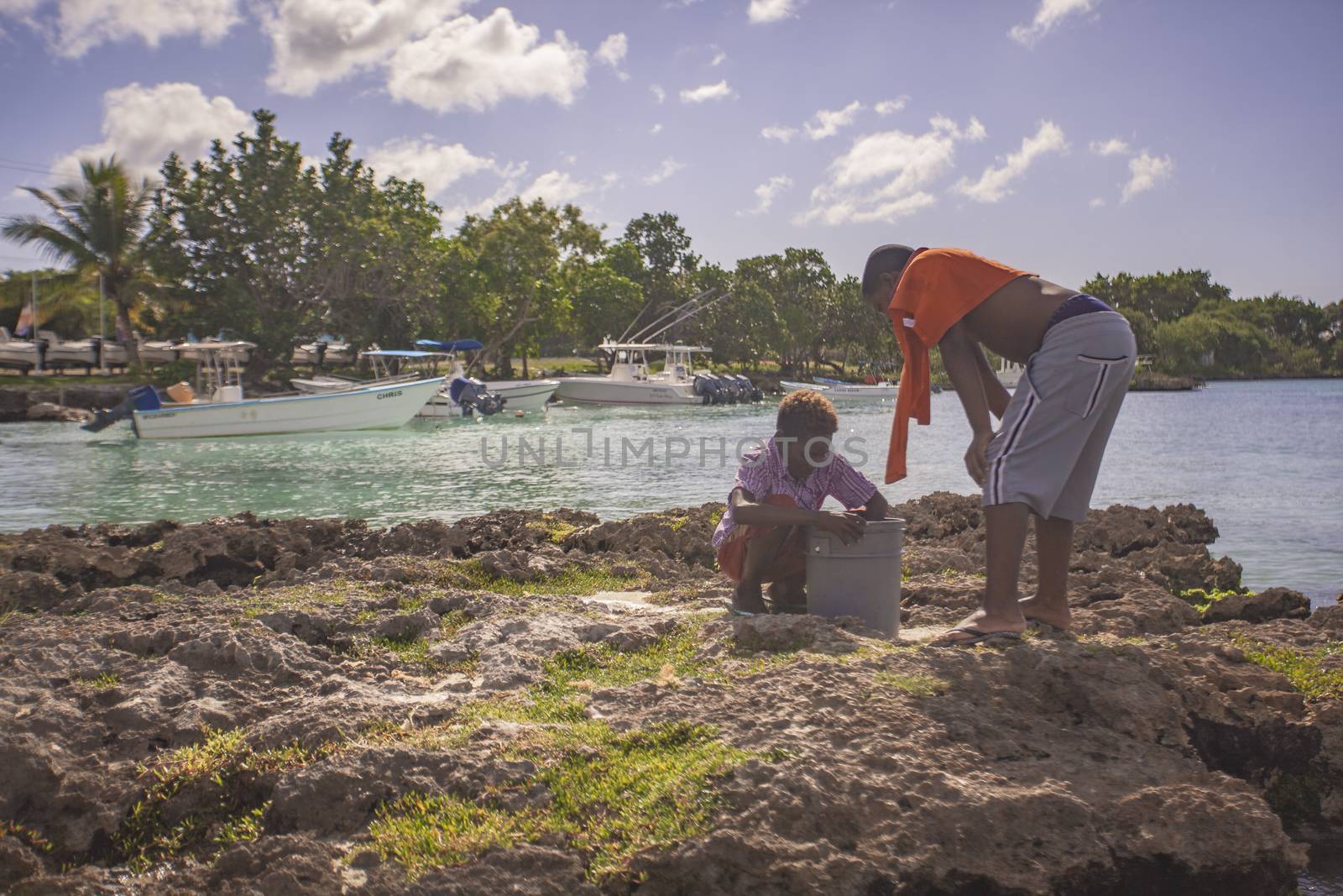 BAYAHIBE, DOMINICAN REPUBLIC 23 DECEMBER 2019: Poor Dominican children play in Bayahibe beach in total happiness and joy