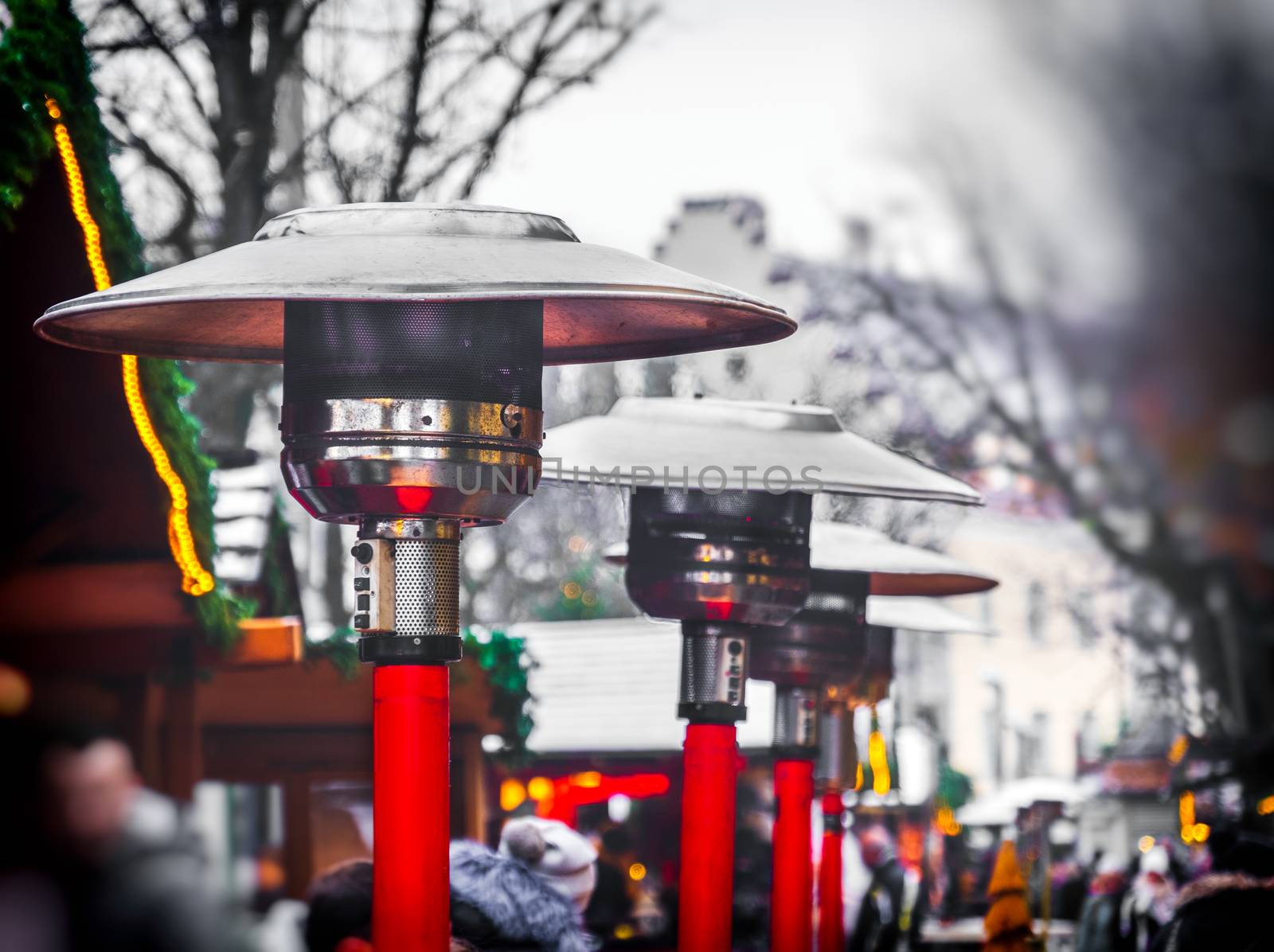 row of gas patio heaters with propane heat lamp on the street in winter day by LucaLorenzelli