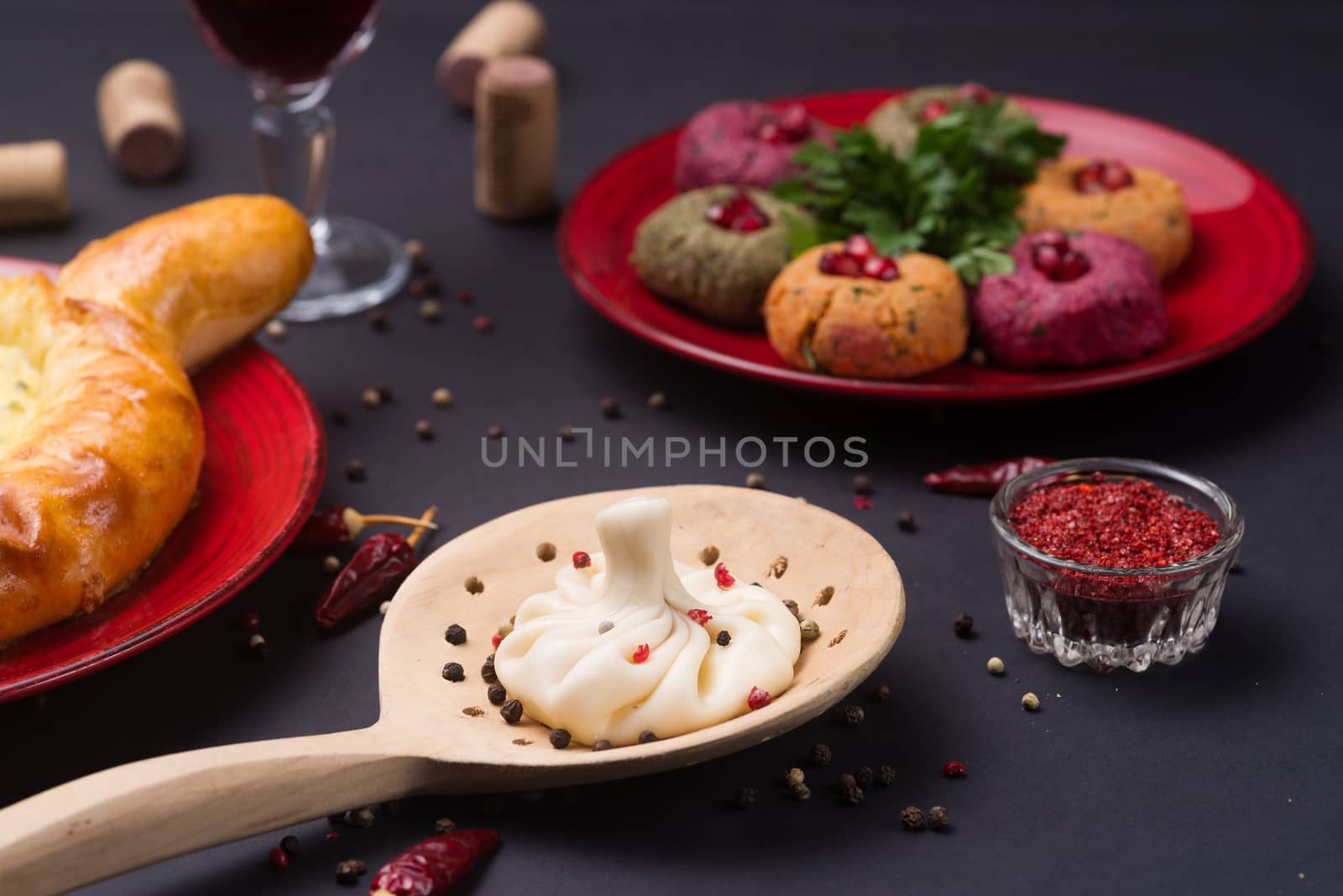 Georgian food on black table. khinkali, phali,  khachapuri with tomatos, adjika and a glass of wine.