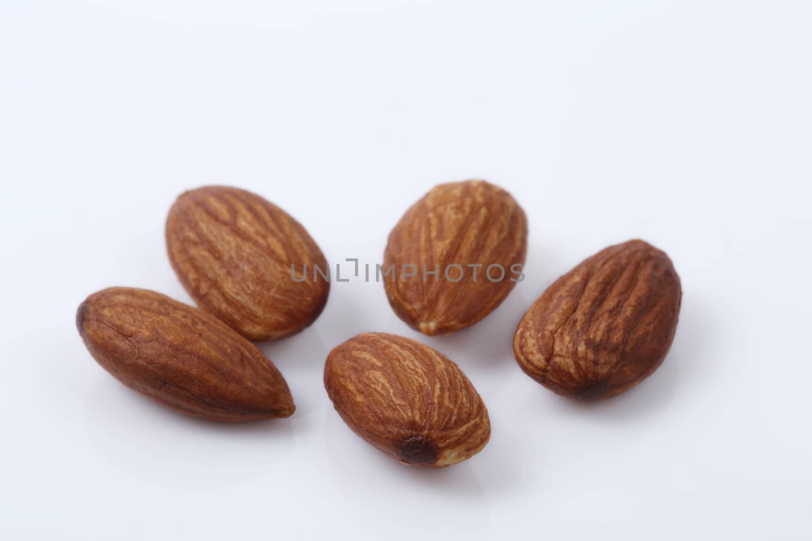 Close up of dry almonds nuts over white background.