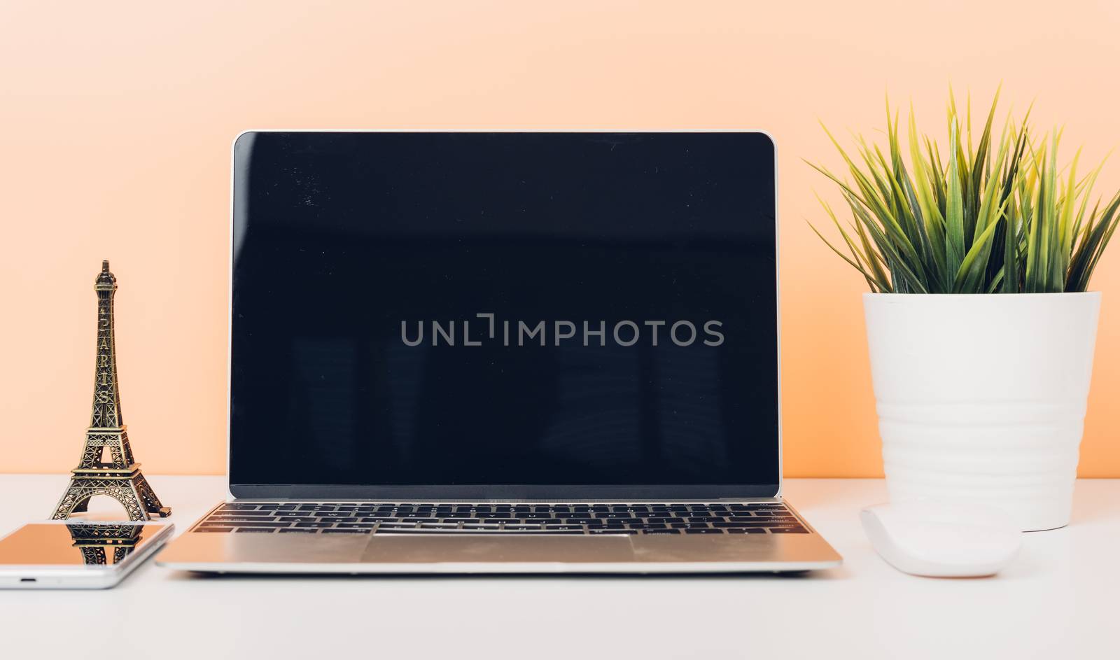Mock up laptop notebook computer on desk table office soft yellow wall and blank screen