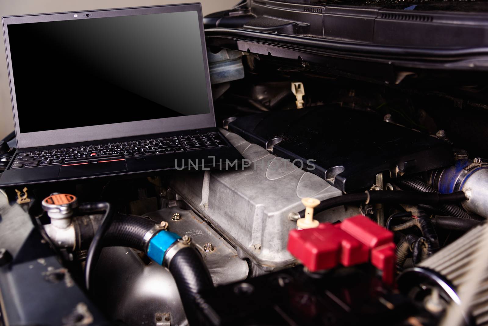 Laptop computer on car mechanic engine for service at workshop