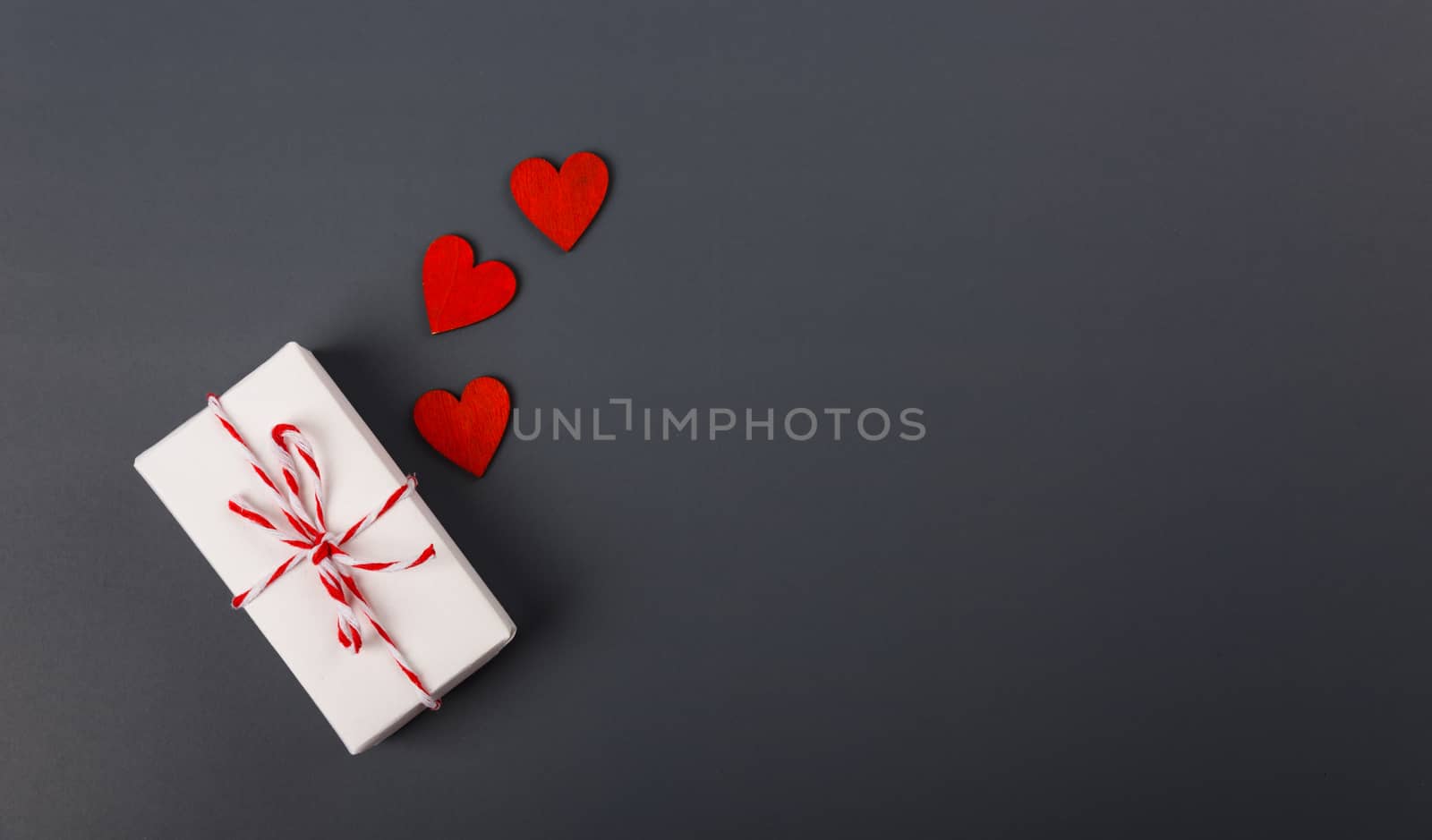 Valentine's day Concept, flat lay top view, White Gift Box and Red Heart on Gray background with copy space for your text