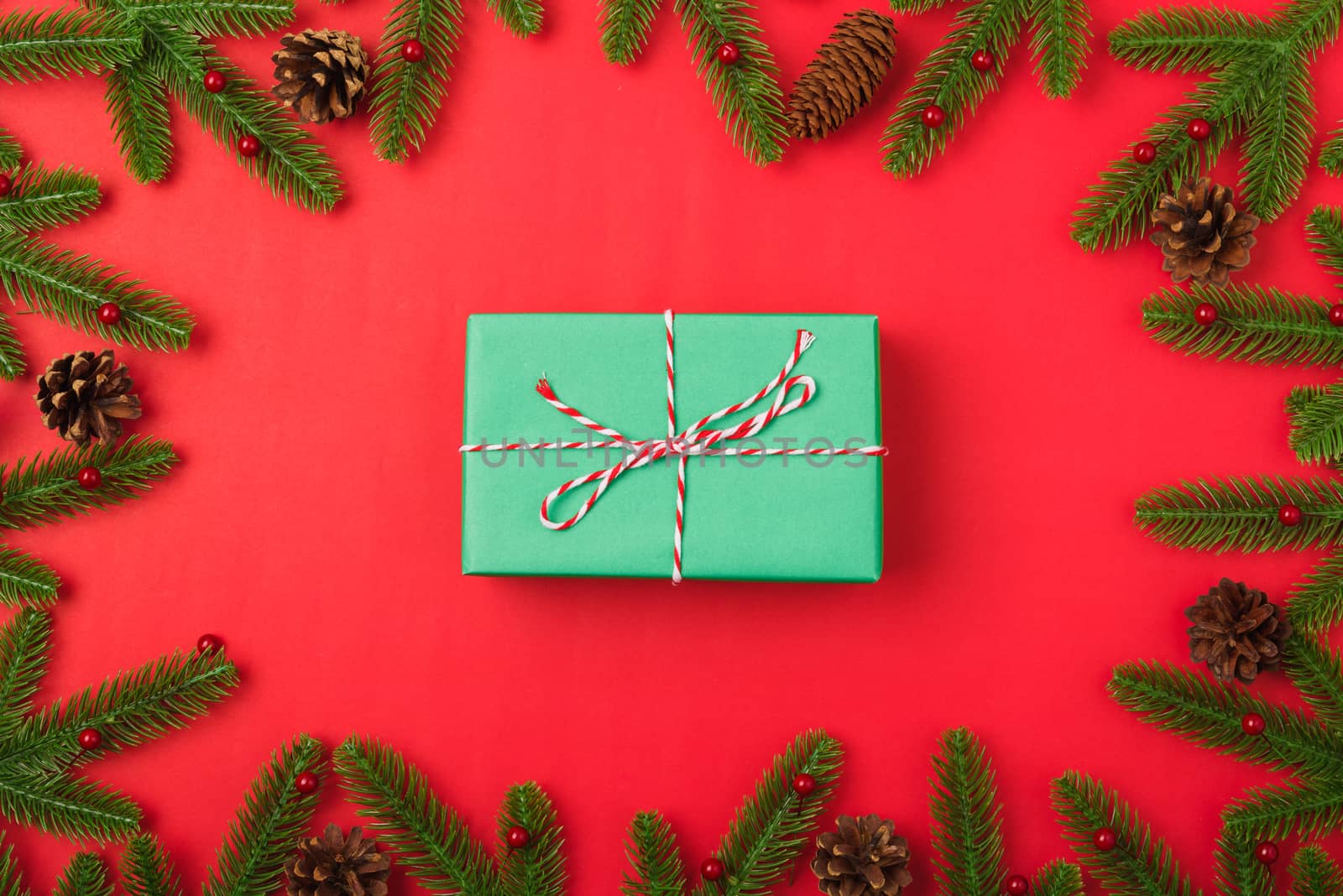 Happy new year or christmas day top view flat lay fir tree branches and gift box, decoration on red background with copy space for your text