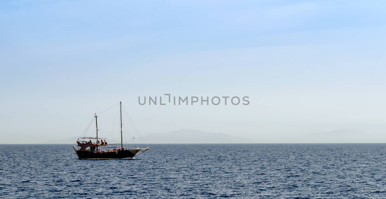 black yacht in the Red Sea on the background of the island in Sharm El Sheikh Egypt
