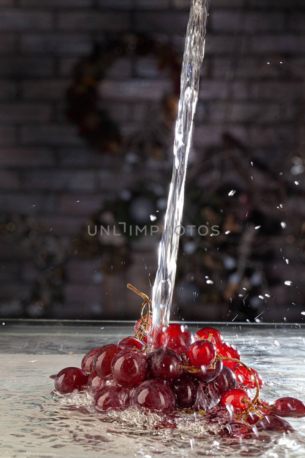 Bunch of grapes and stream of water on a studio background