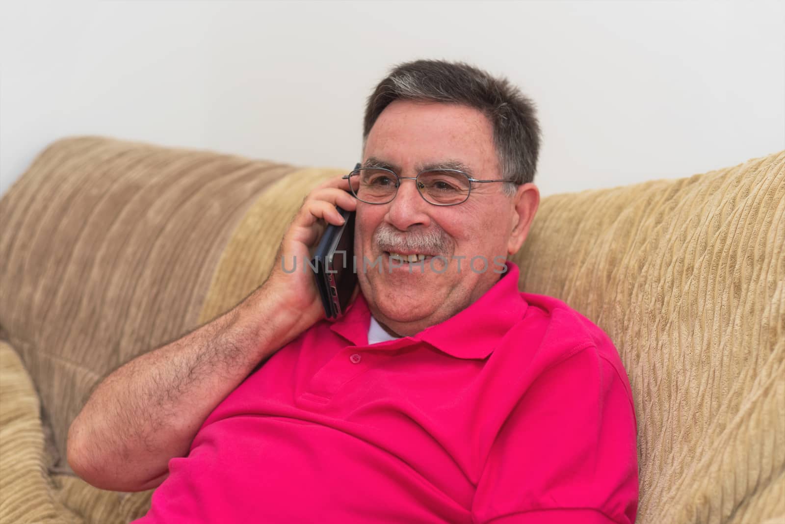 Portrait of a senior man happy talking on the phone by HERRAEZ