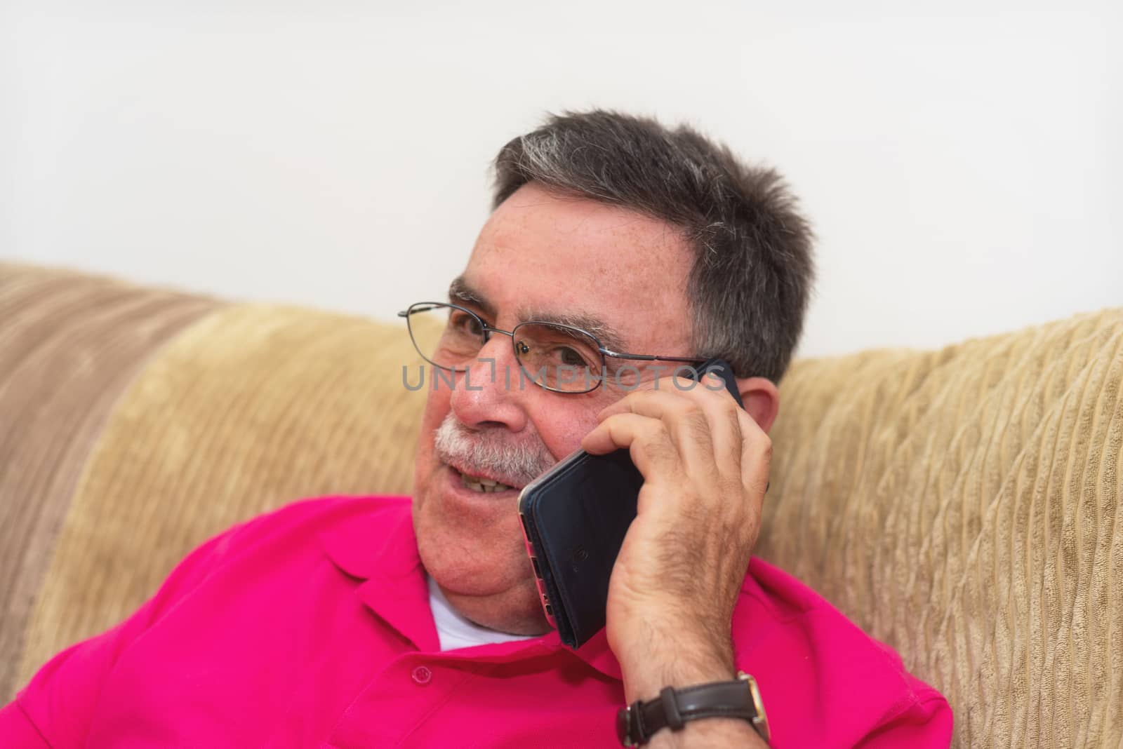 Portrait of a senior man happy talking on the phone by HERRAEZ