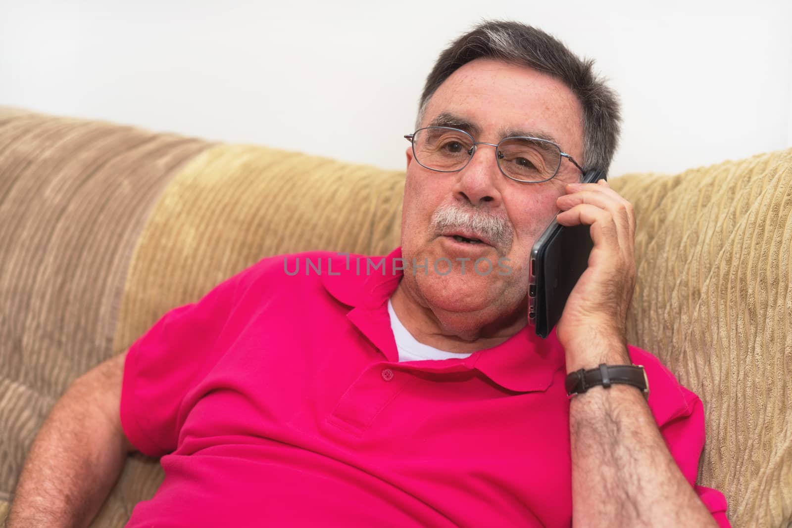 Portrait of a senior man happy talking on the phone by HERRAEZ