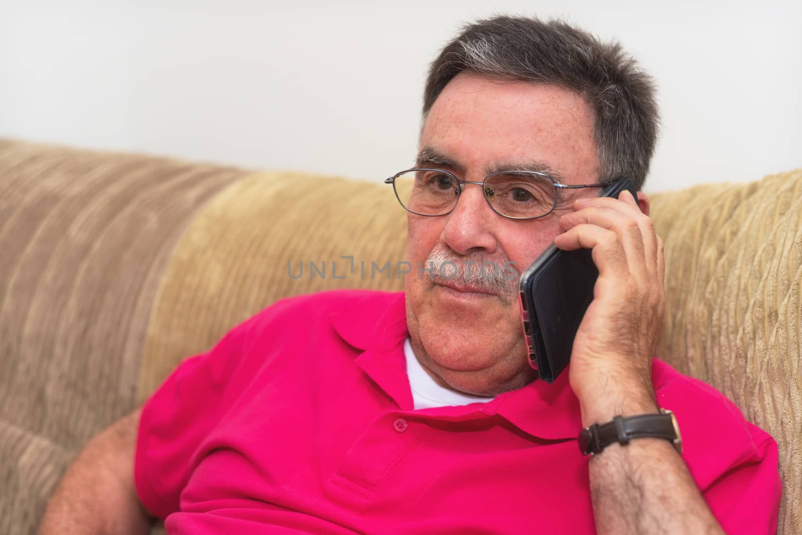 Portrait of a senior man happy talking on the phone by HERRAEZ