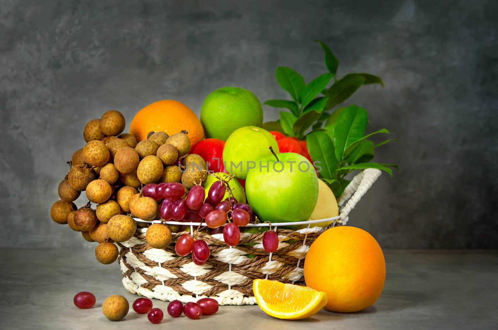 fresh vegetables and fruits in wicker basket over wooden background