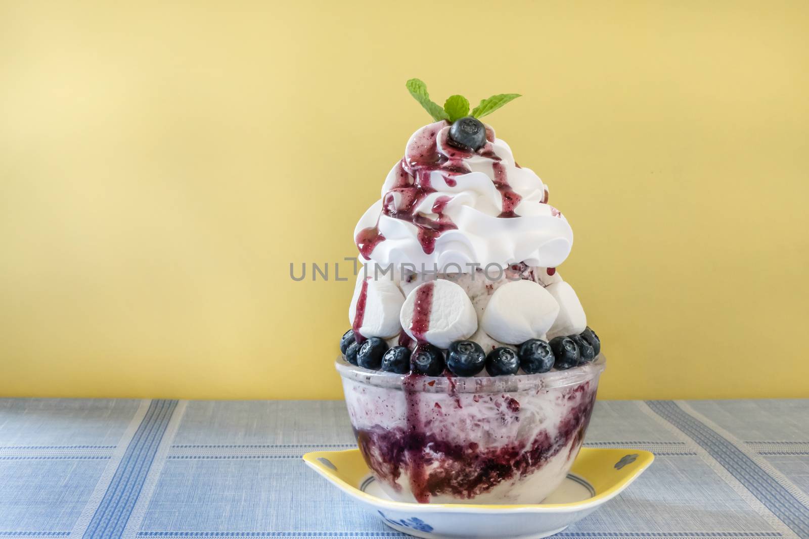 Bingsu - Korean shaved ice dessert with sweet toppings with marshmallow and blueberries