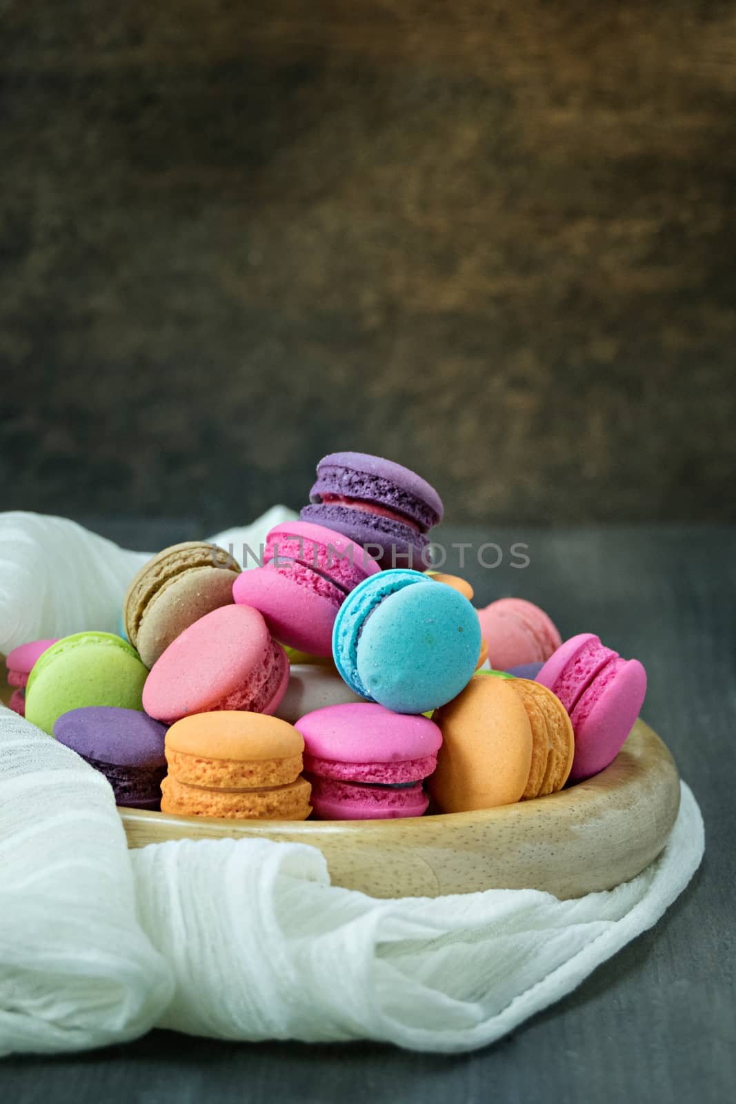 colorful of macarons on plate over wooden table