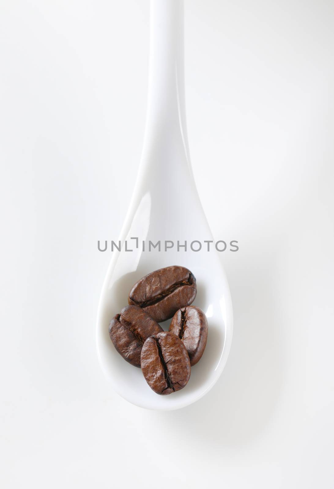 Roasted coffee beans on spoon by Digifoodstock