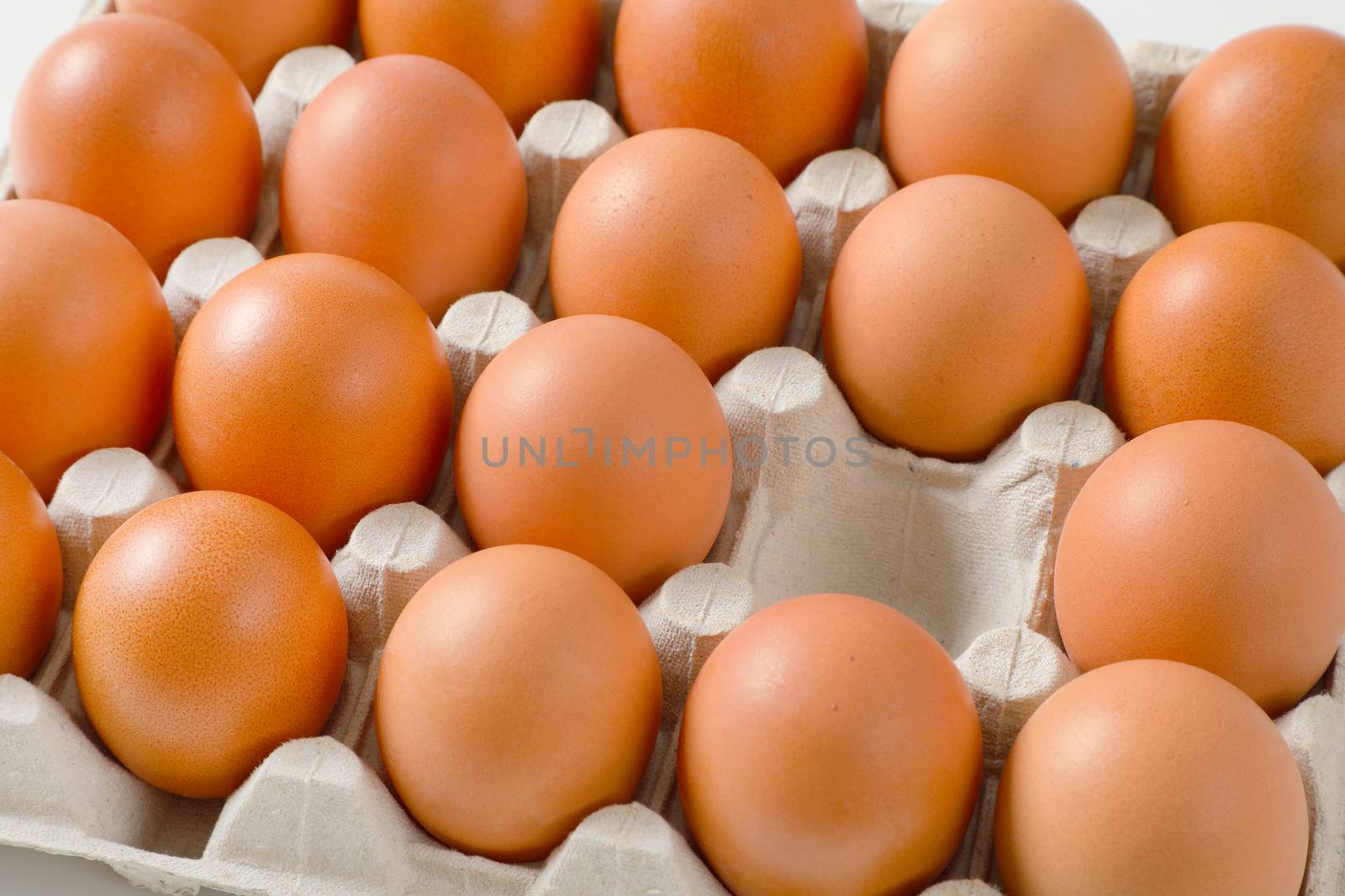 Fresh brown eggs in paper carton by Digifoodstock