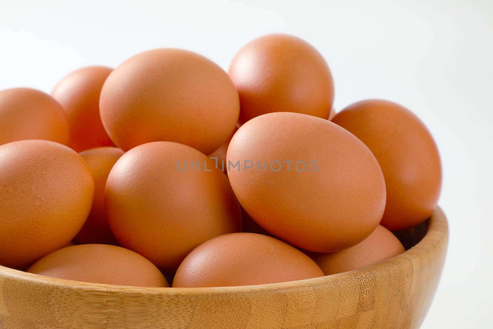 Fresh brown eggs in wooden bowl