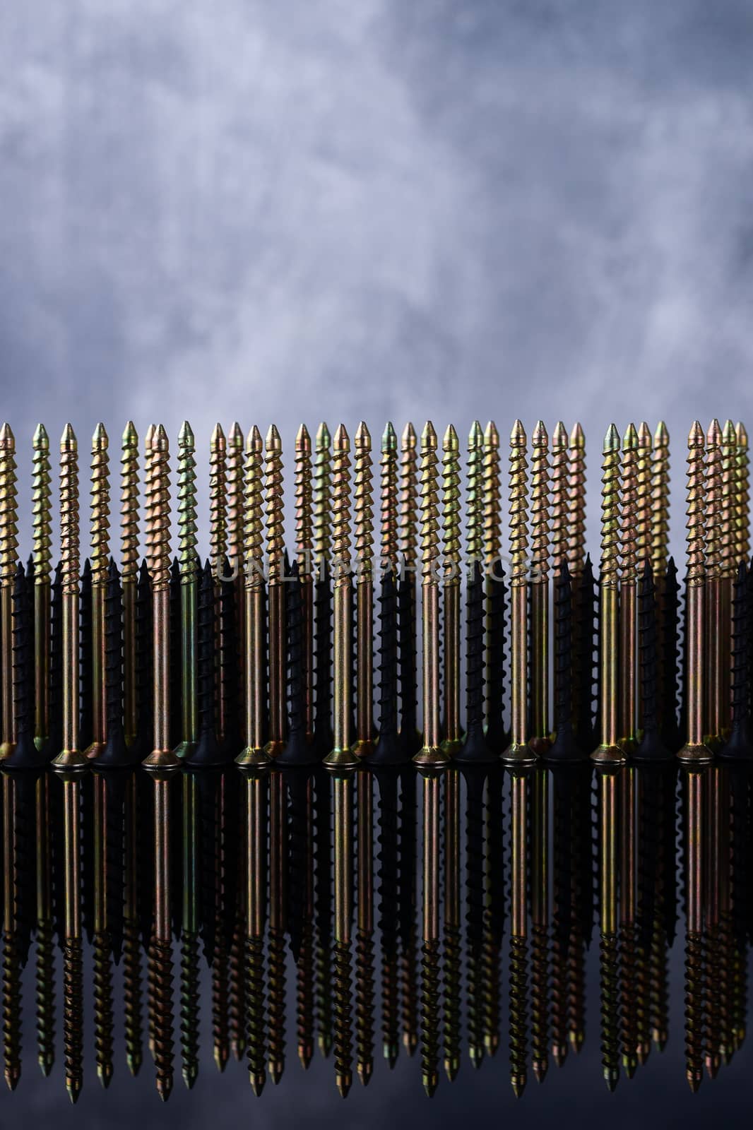 Screws and dowels on glass on beton background. Symbol of team work, invincibility and power of team army. Creative photo of screws and dowels.