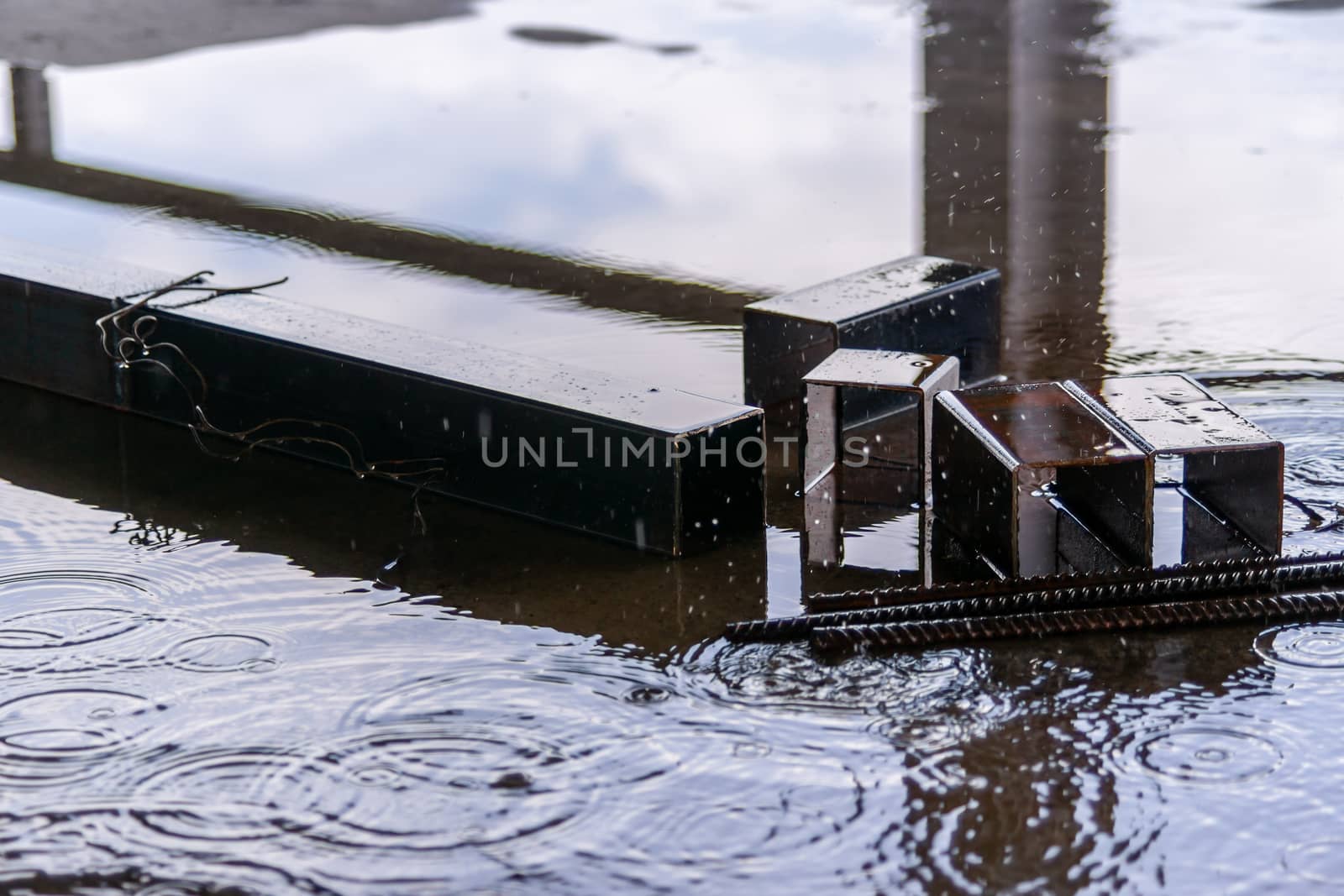 Rain drops and water on concrete with sky reflection in water by alexsdriver