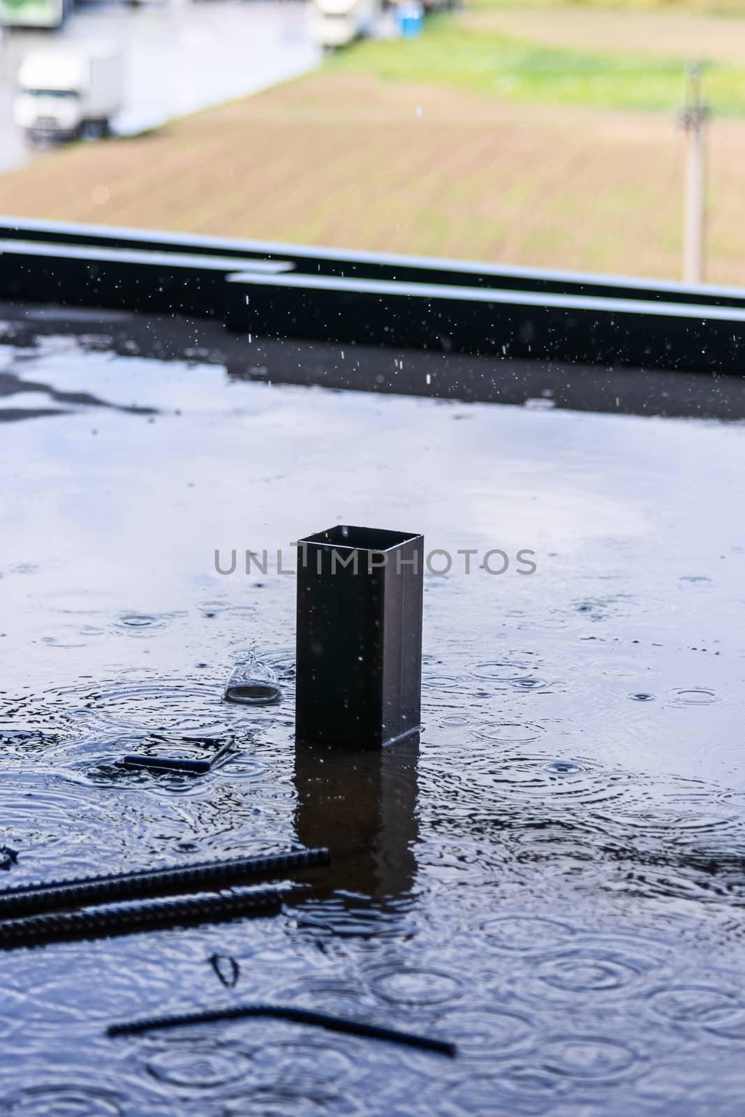 Rain drops and water on concrete with sky reflection in water