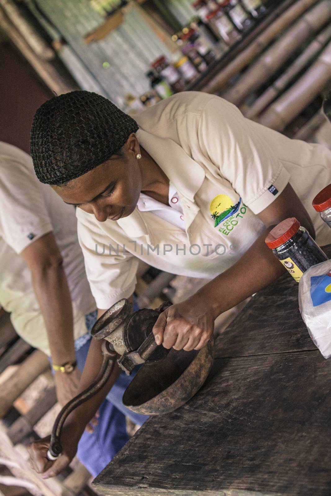 MONTANA REDONDA, DOMINICAN REPUBLIC 27 DECEMBER 2019: Dominican woman grinds coffee with traditional methods