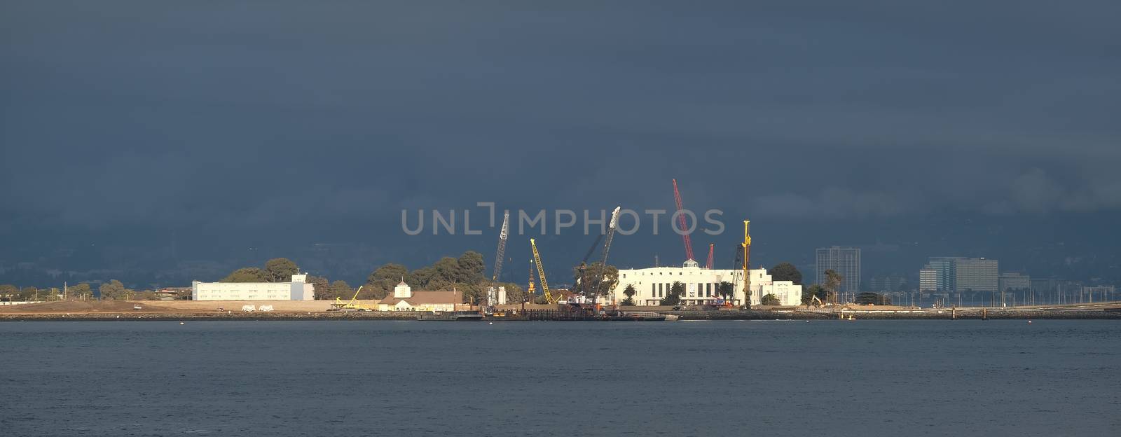 Construction Cranes on Stormy Coast by dbvirago