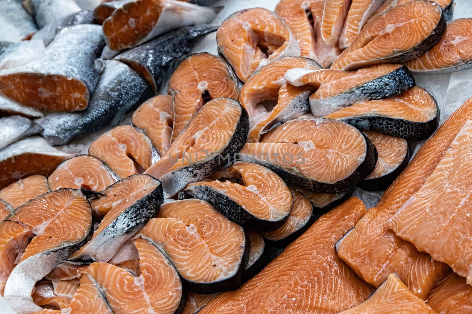 Different types of fresh fish on ice in supermarket, top view. Close up fresh fish on ice bucket or frozen fish in grocery store use for raw food background