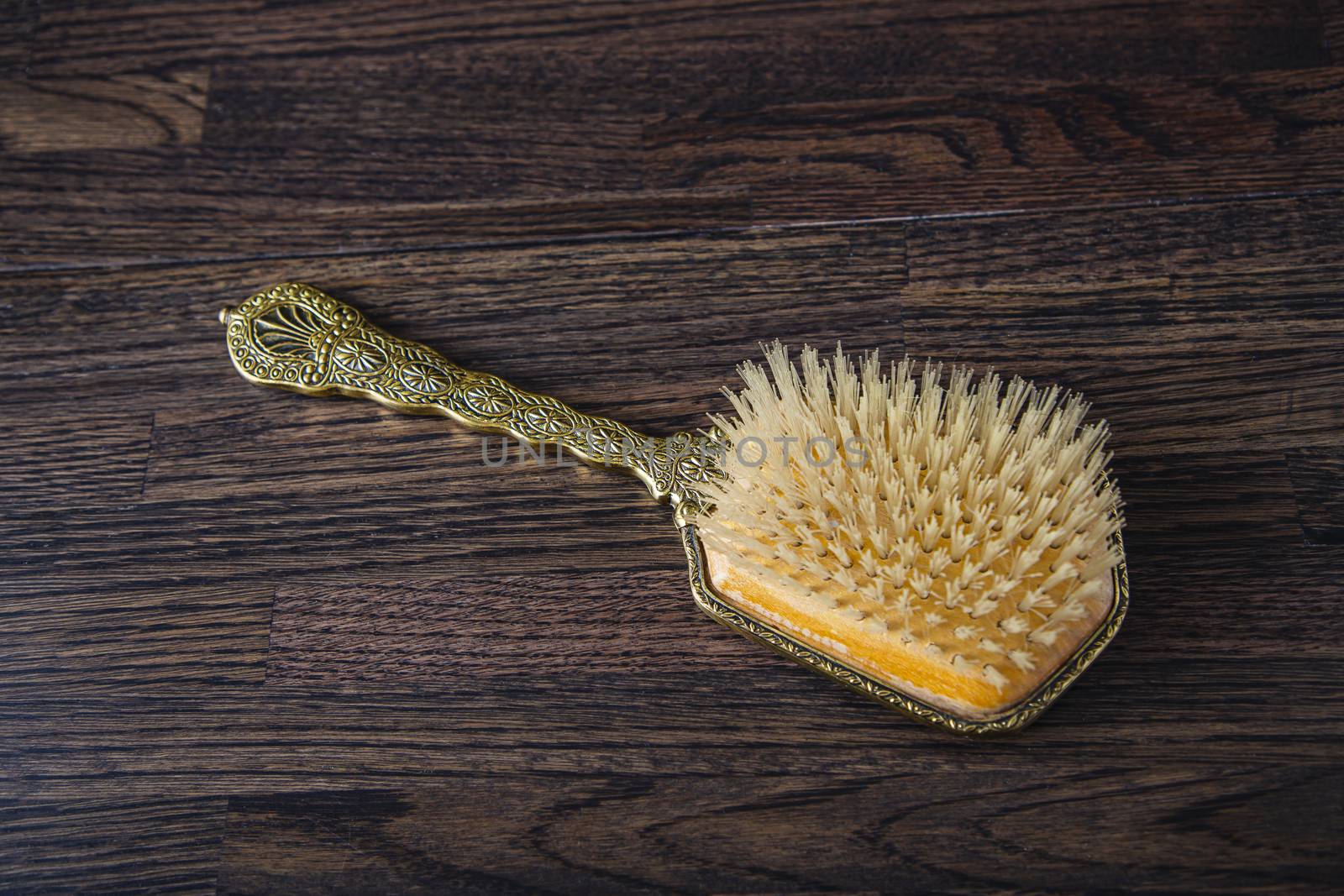 Antique hair brush on a dark oak wood background